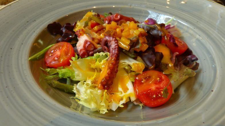 Ensalada de brotes tiernos, pulpo ahumado, melocotón ecológico carmelizado, panceta de Cal Tomás y su vinagreta